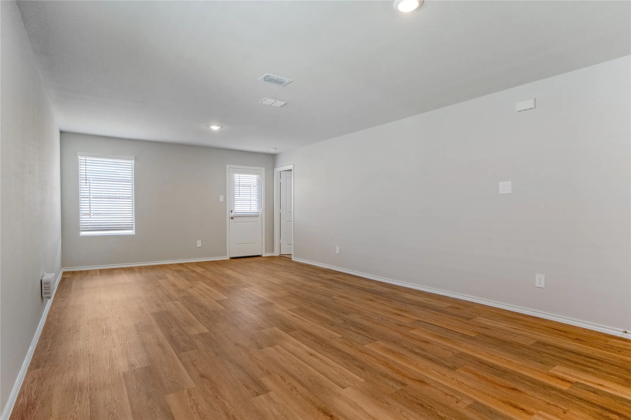 Open interior space featuring wood-finish flooring, recessed lighting, and a neutral color palette