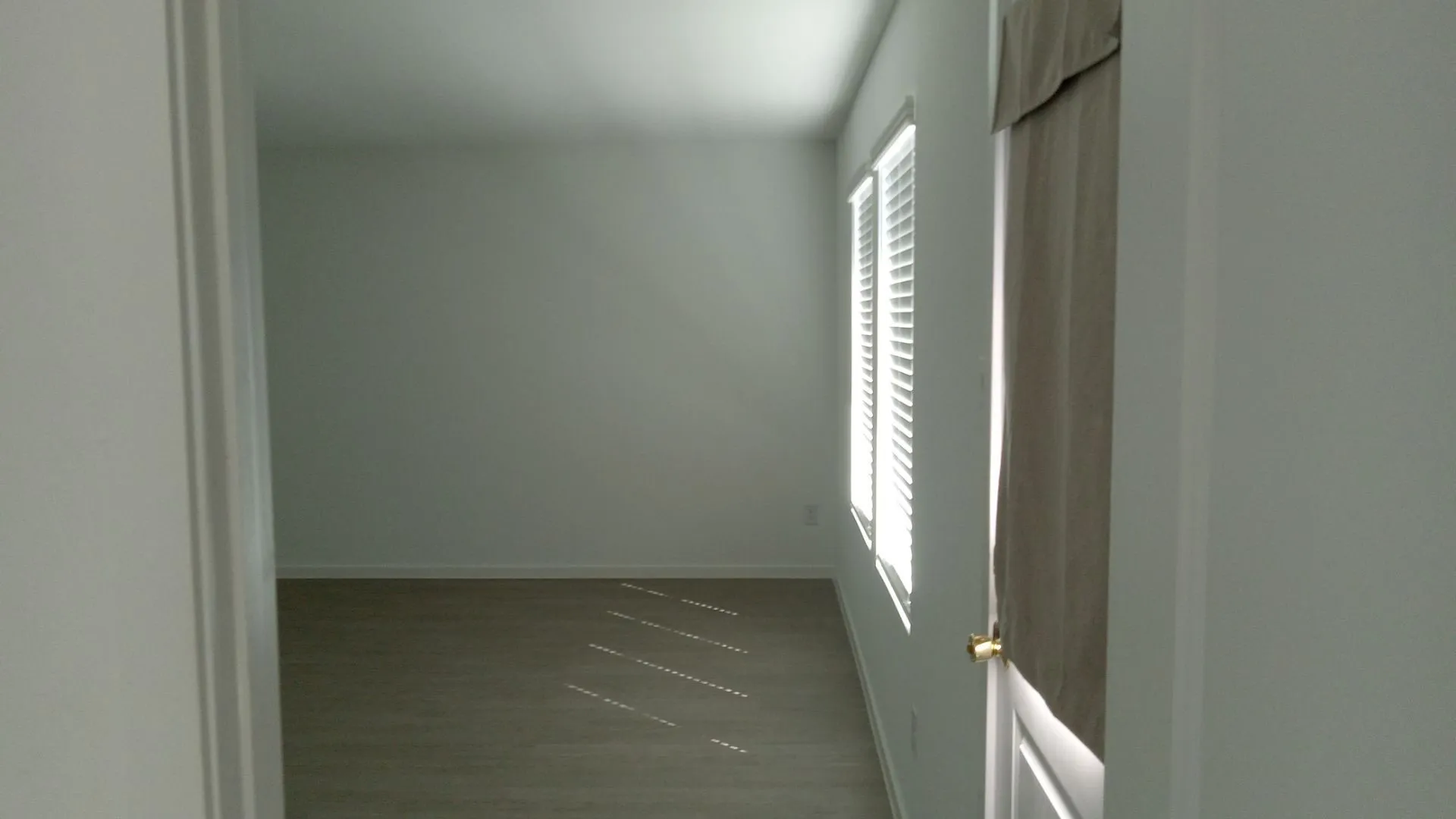 Neutral-toned walls, wood-finish flooring, and multiple windows with installed blinds