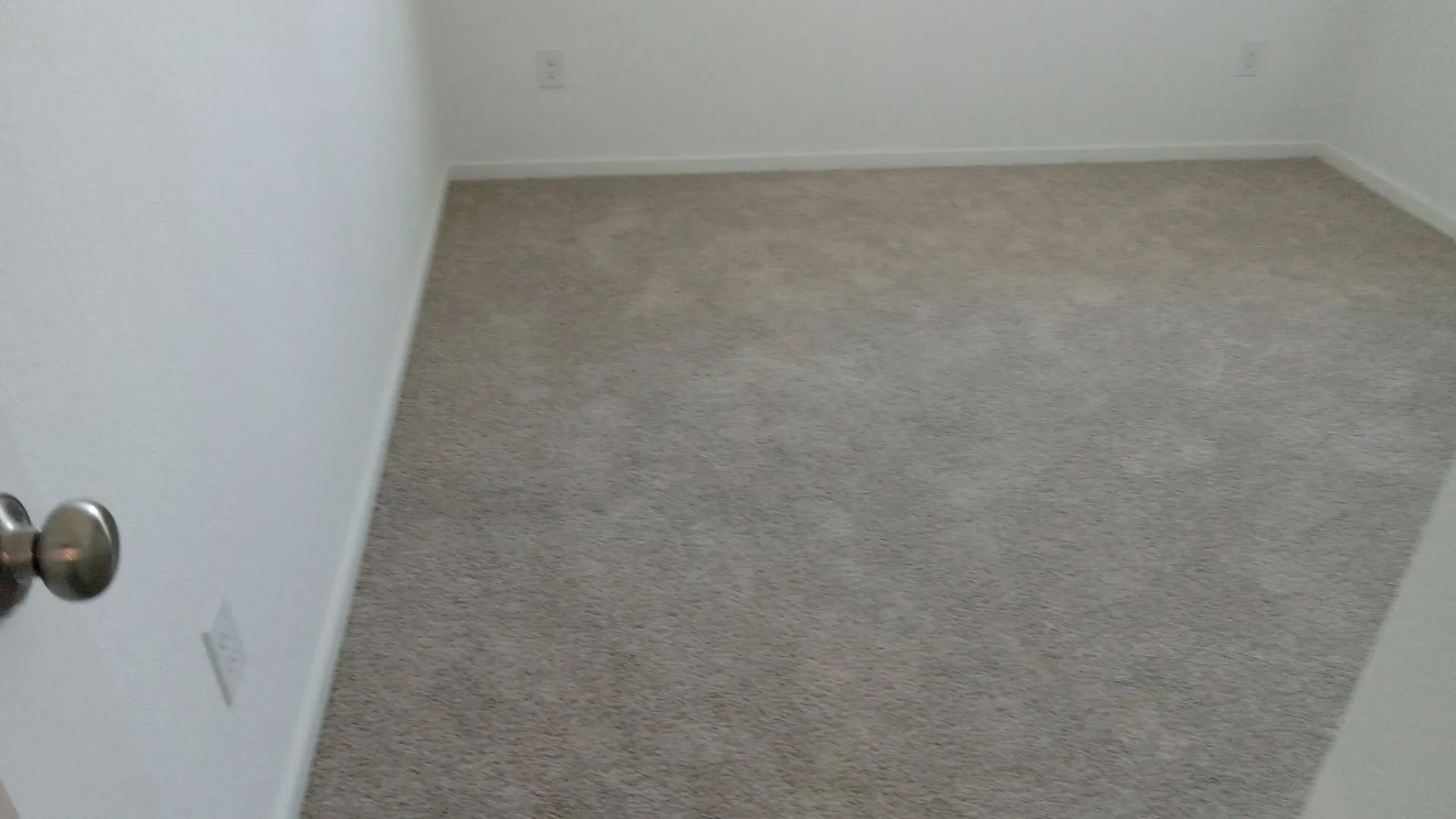 Neutral-toned wall-to-wall carpeting and smooth, white wall finishes
