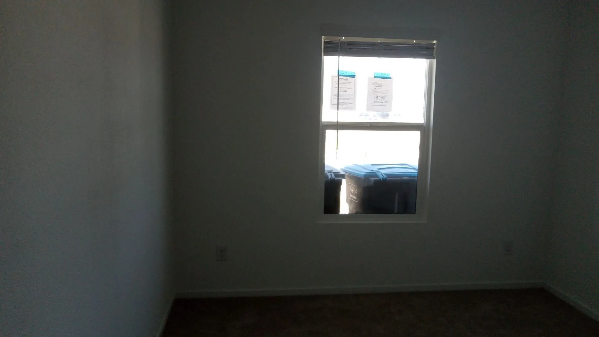 Neutral-toned interior room featuring wall-to-wall carpeting and a single-hung window with integrated blinds
