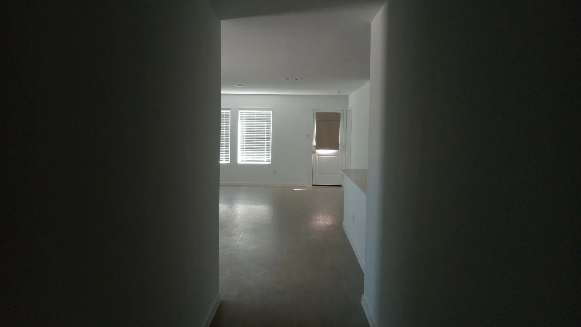 Interior space featuring smooth-finish wall surfaces, recessed lighting, multi-pane windows, and a panelled exterior-style door