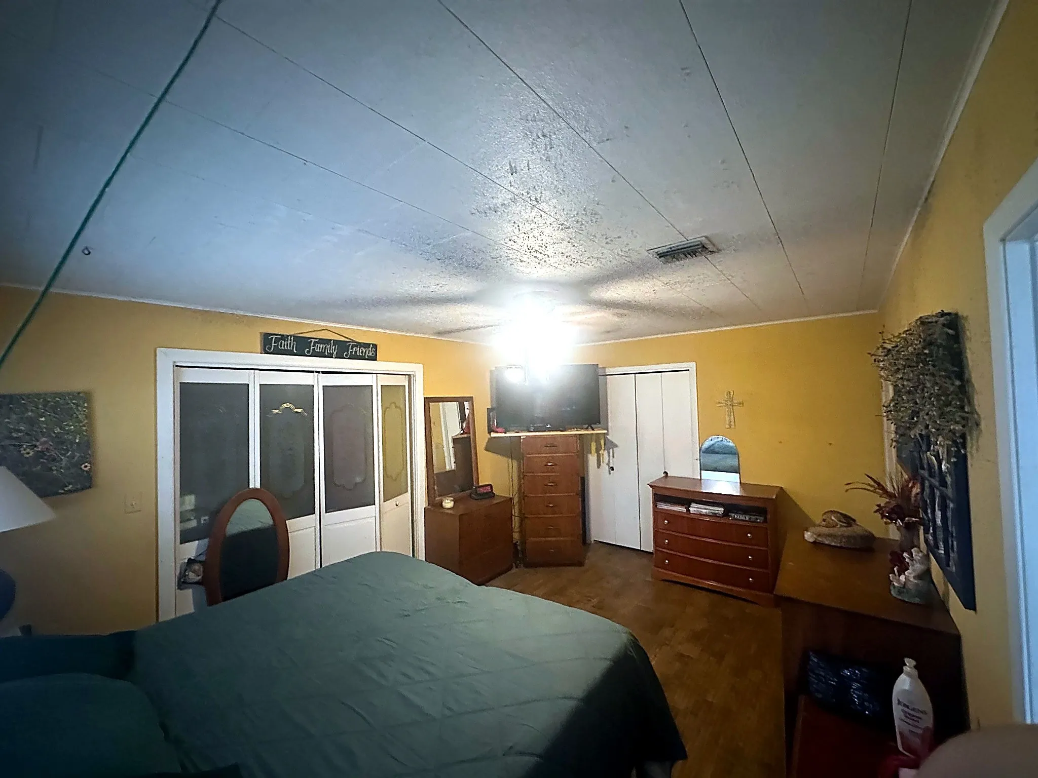Interior space featuring wood-finish flooring, white paneled closet doors, and a ceiling-mounted light fixture