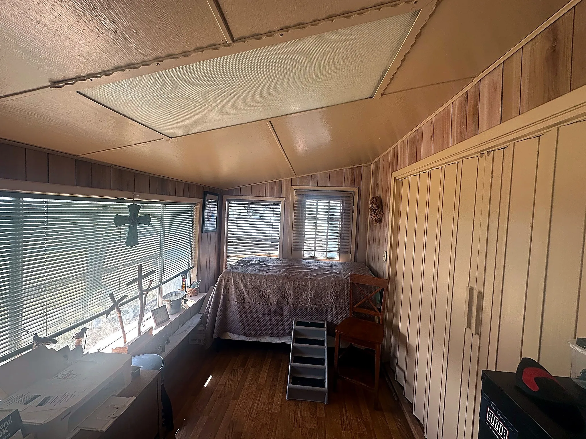 Wood-finish paneling, wood-finish flooring, recessed lighting, and expansive windows featuring horizontal blinds