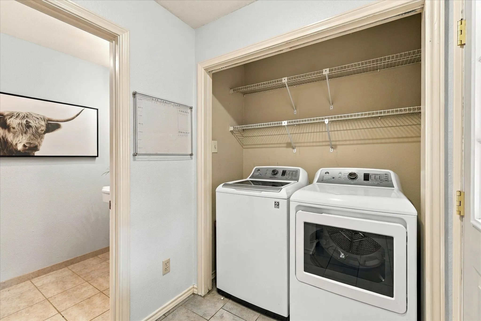 Laundry area featuring tile flooring and two-tier wire shelving