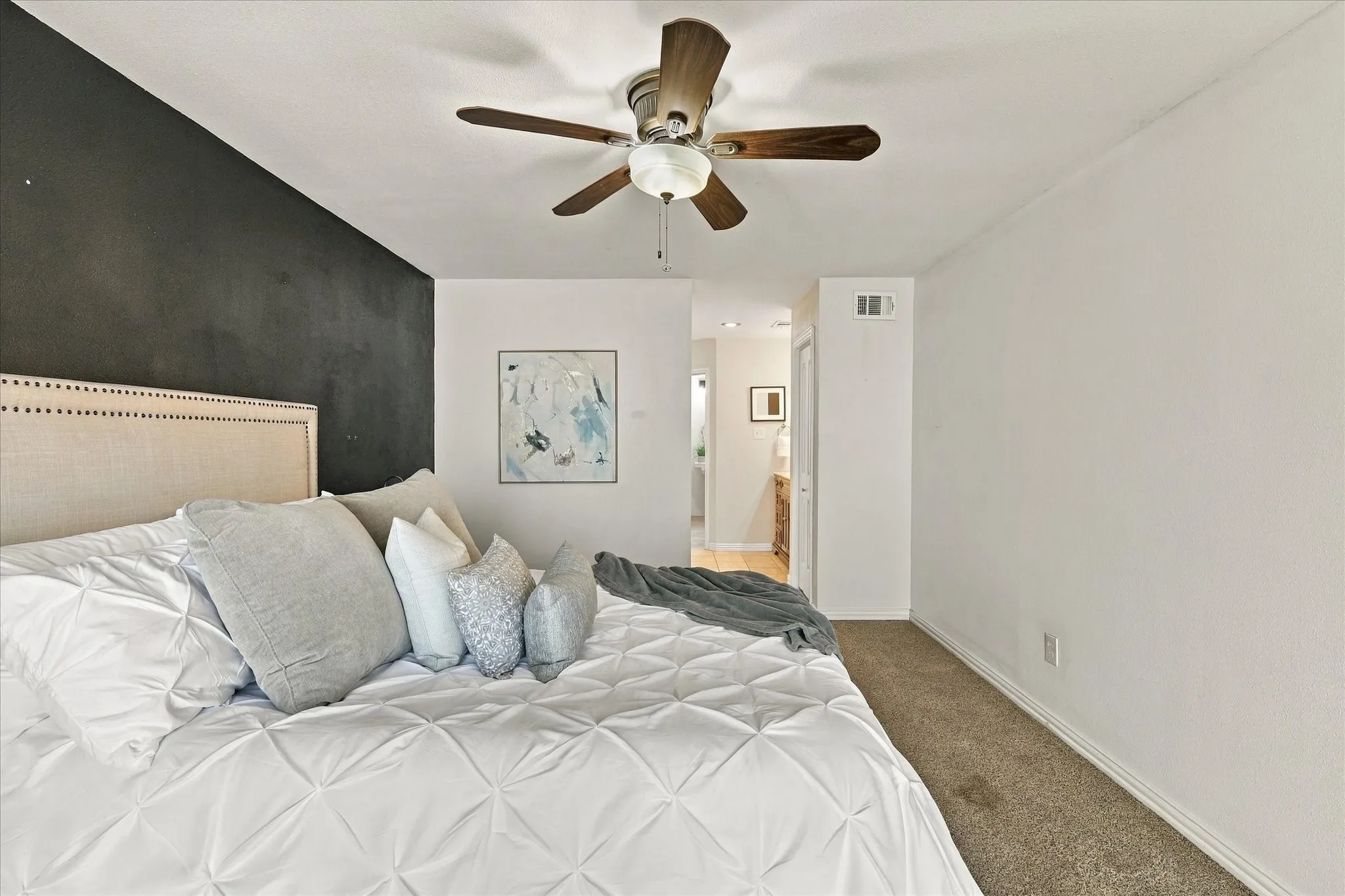 Accent wall featuring a matte dark finish, carpeted flooring, and a central ceiling fan with integrated​​‌​​​​‌​​‌‌​‌‌​​​‌‌​‌​‌​‌​​​‌​​ lighting