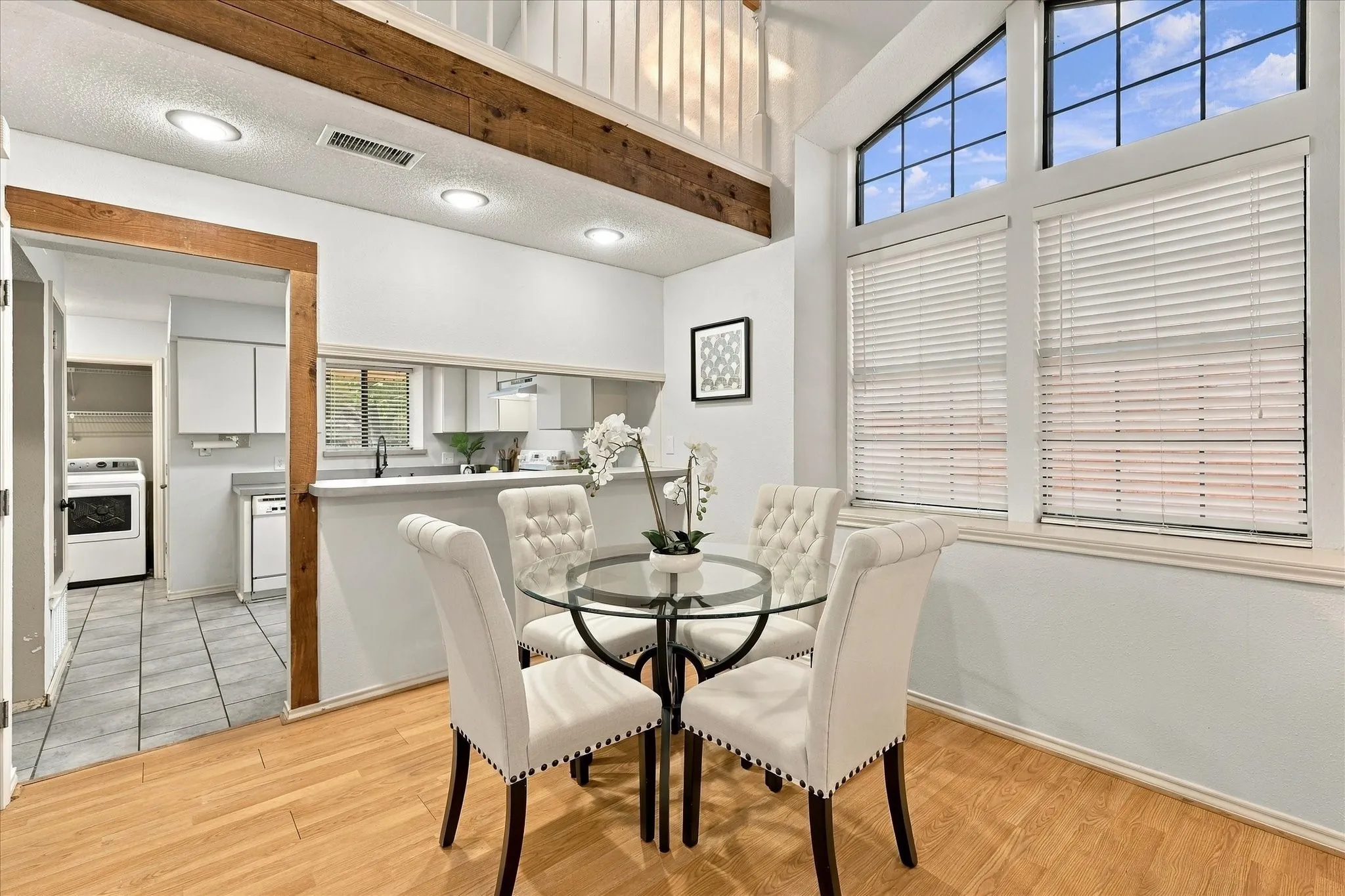 Vaulted ceilings featuring exposed wood beams, wood-finish flooring, floor-to-ceiling windows, and recessed lighting