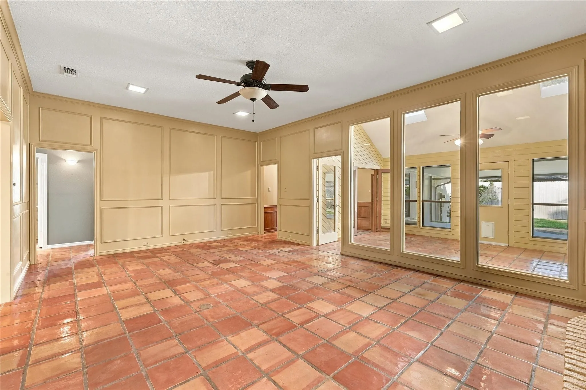Living area with high ceilings and views into the sunroom.