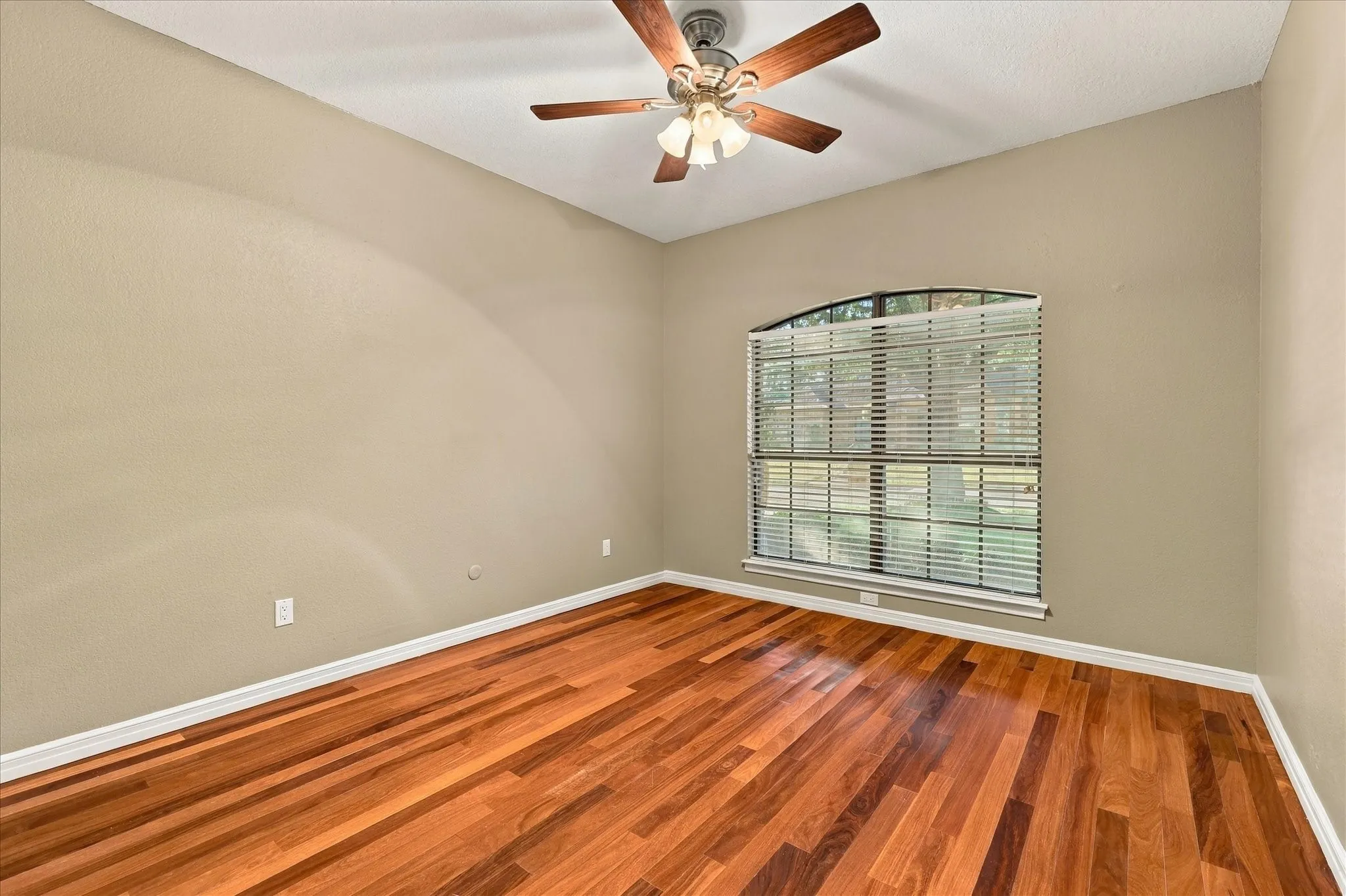 Secondary bedroom with wood flooring and natural light.