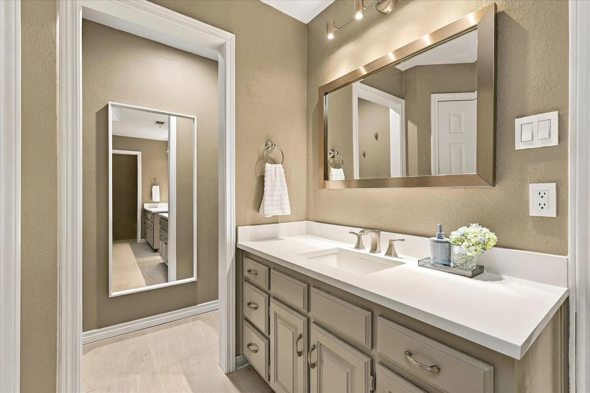  Primary bathroom with two sinks and vanity storage.