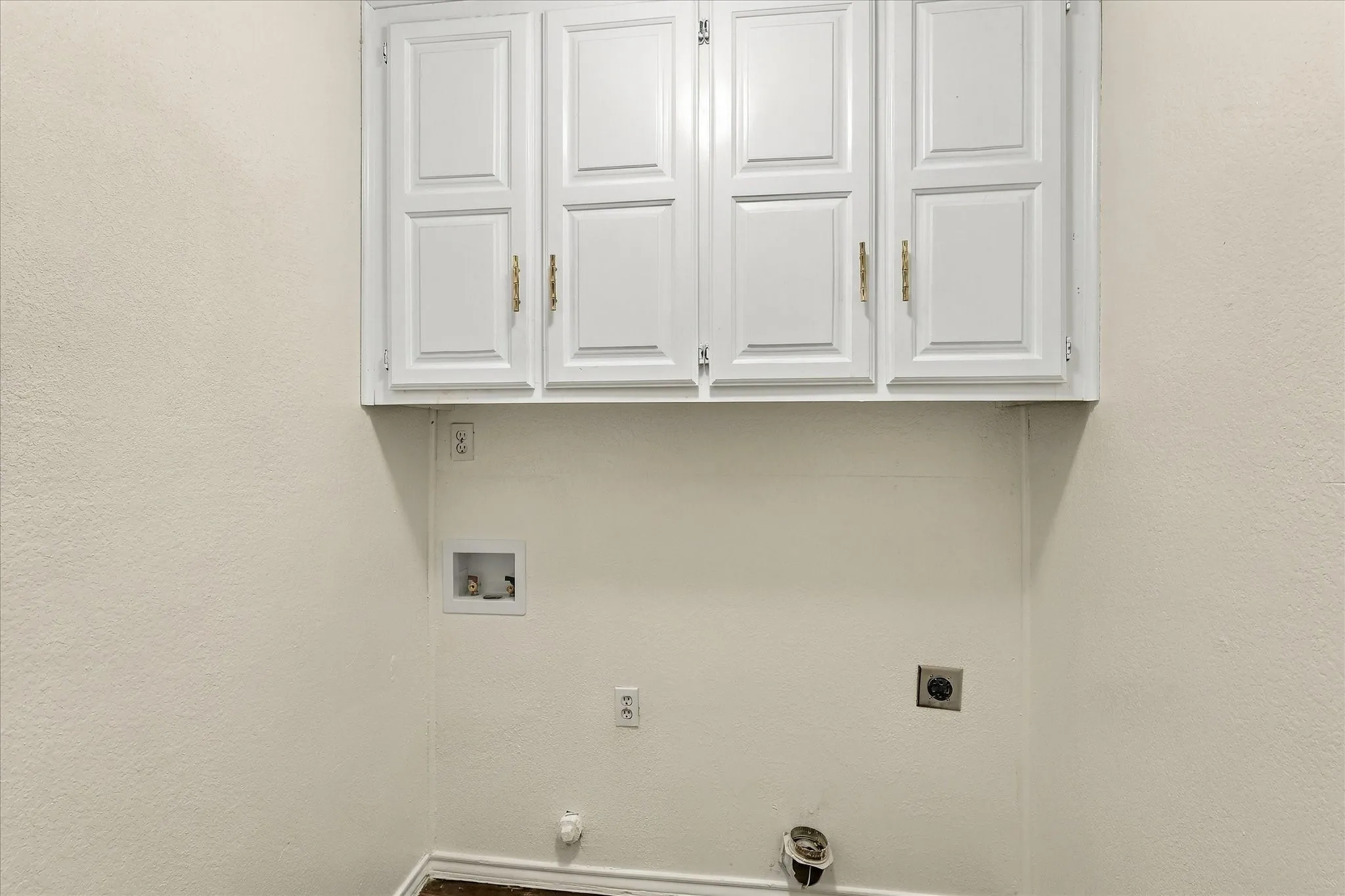 Laundry area with overhead cabinets.
