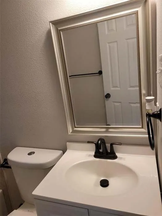 Vanity featuring an integrated sink, matte black faucet, framed wall mirror, and matte black hardware