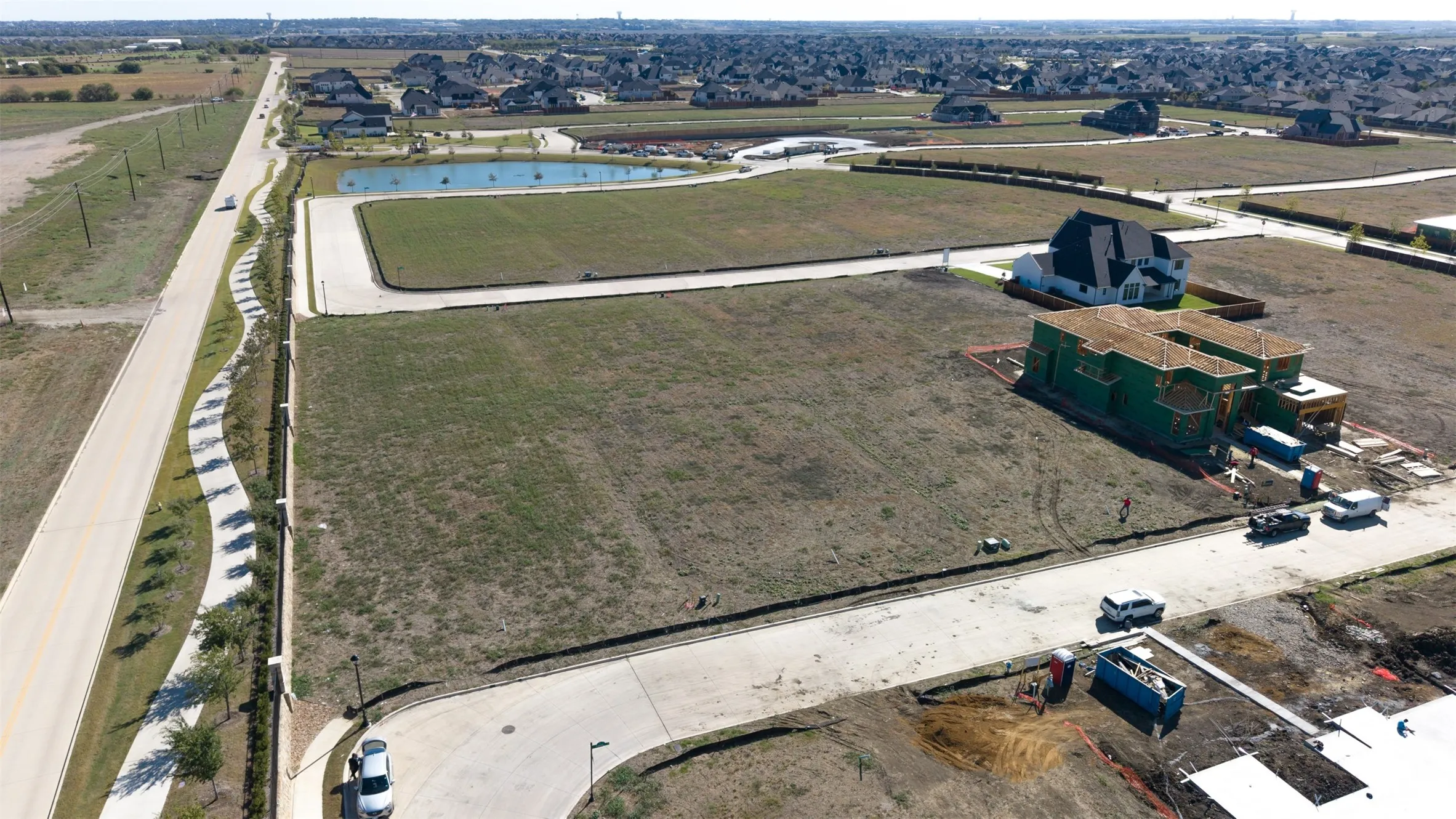 Expansive residential lot featuring concrete street frontage, established infrastructure, and proximity to a neighborhood pond