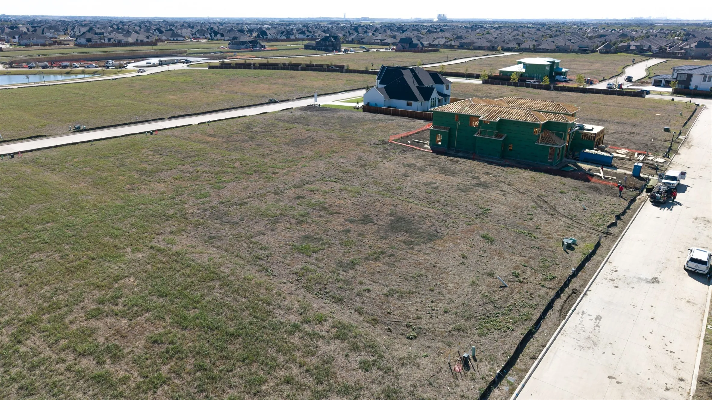 Expansive residential lot featuring concrete street frontage, established utility infrastructure, and a corner lot orientation