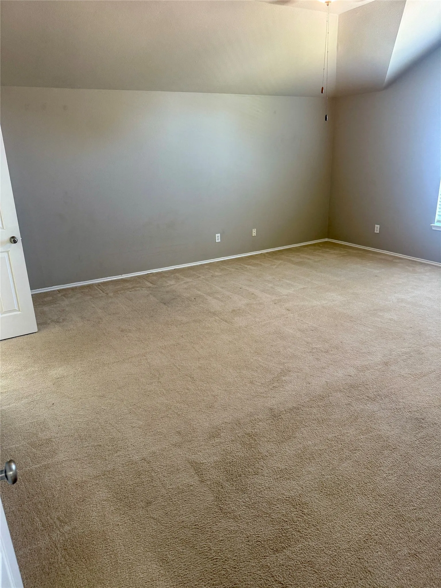Room featuring a vaulted ceiling and wall-to-wall carpeting
