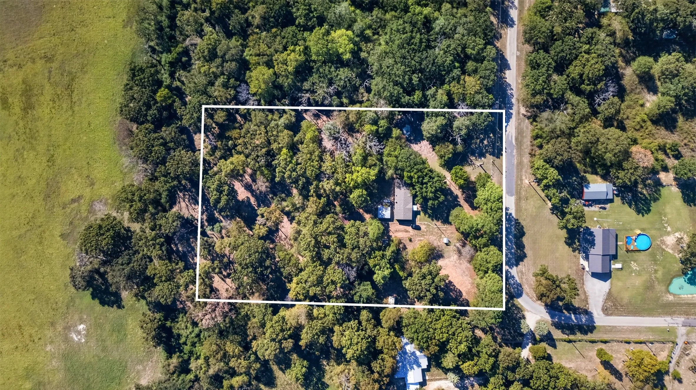 Wooded acreage featuring established tree canopy and a defined rectangular parcel boundary
