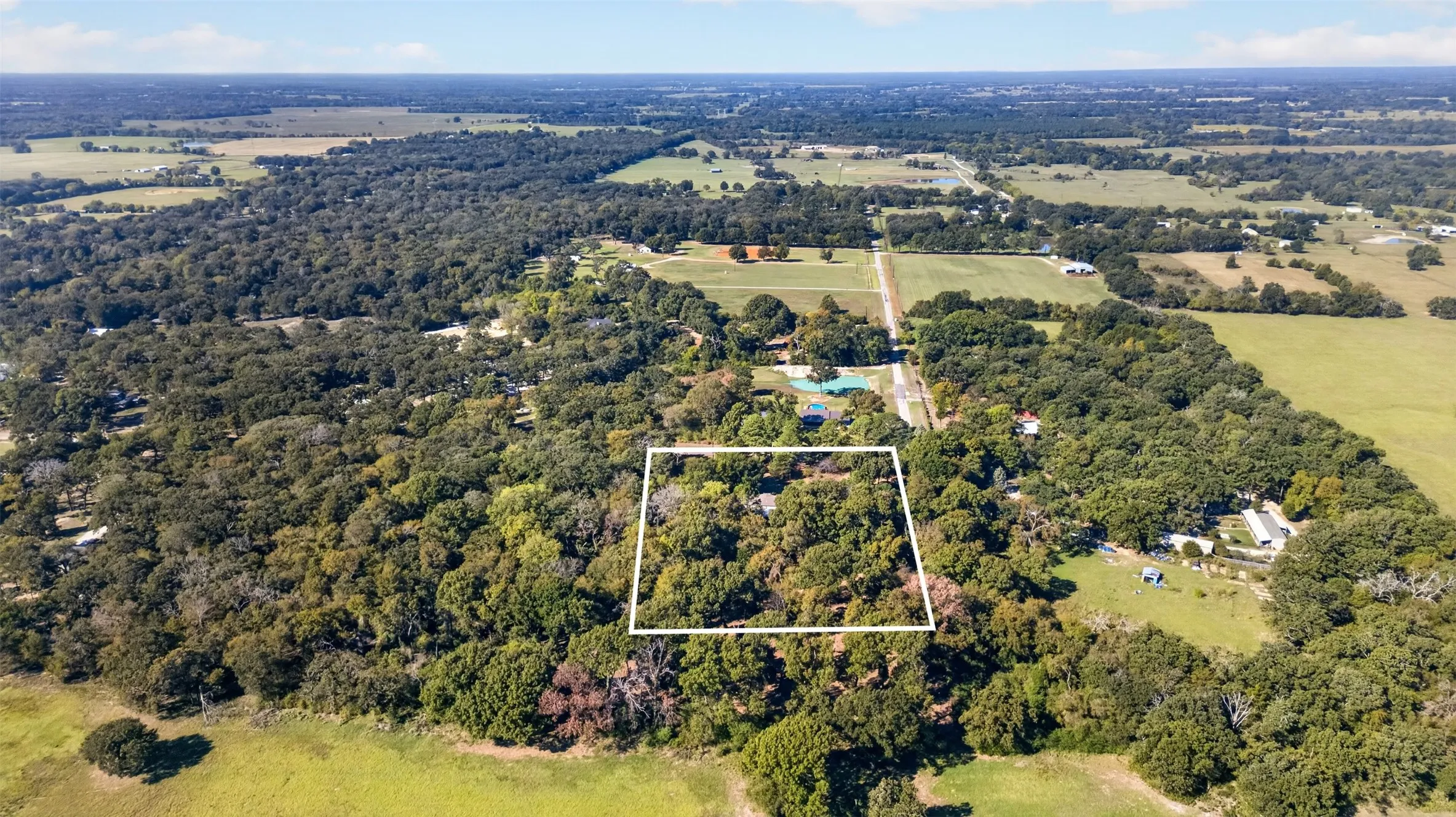Aerial perspective of a large parcel featuring dense mature tree coverage and established natural landscape