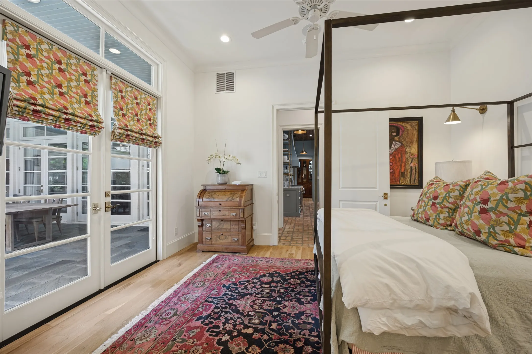 Light-filled space featuring wood-finish flooring, full-height glass paneled doors with transom windows, and an integrated ceiling fan with light fixture