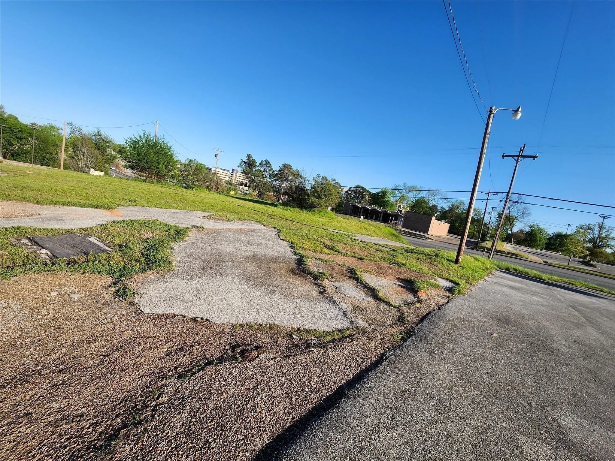 Expansive parcel of land featuring level topography, paved hardscaping, and established grass coverage