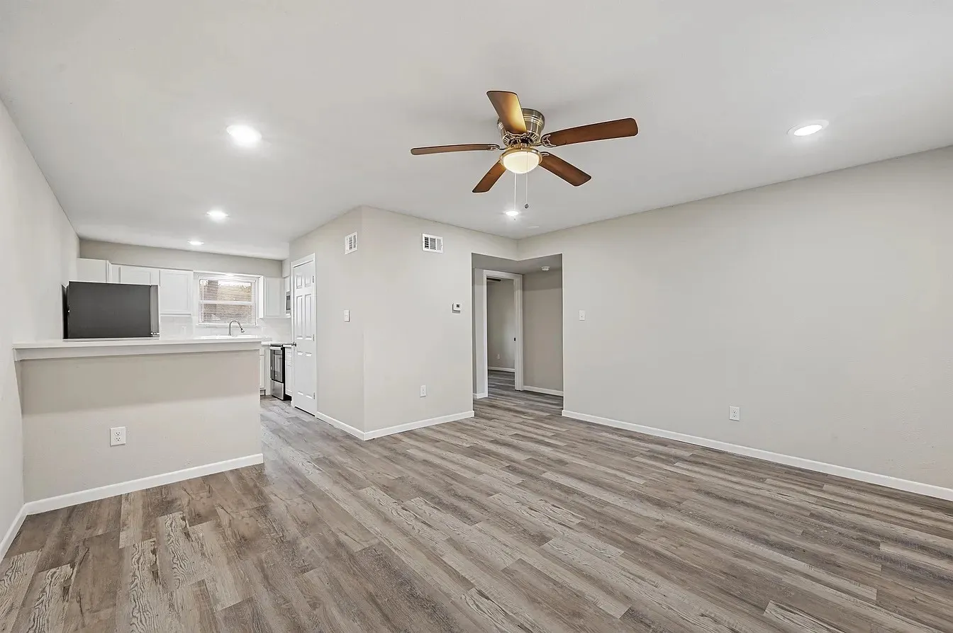 Wood-finish flooring, recessed lighting, ceiling fan with light fixture, and pass-through counter