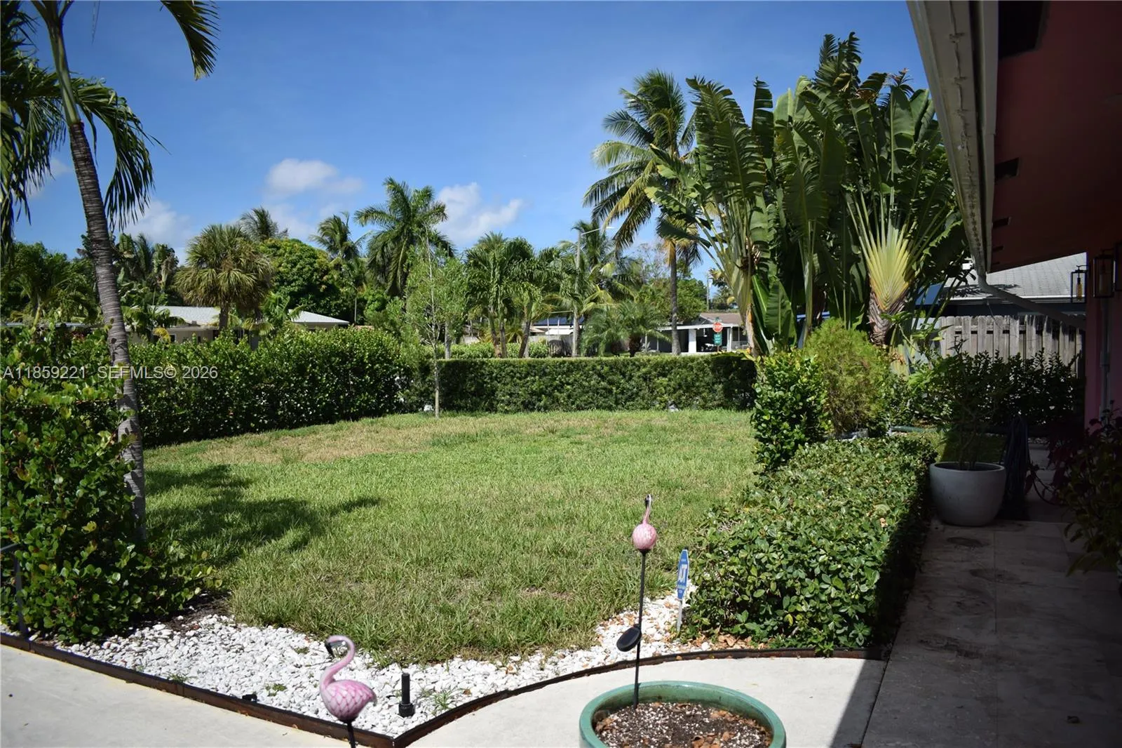 Private front yard framed by lush hedges, offering the perfect setting for a future pool oasis
