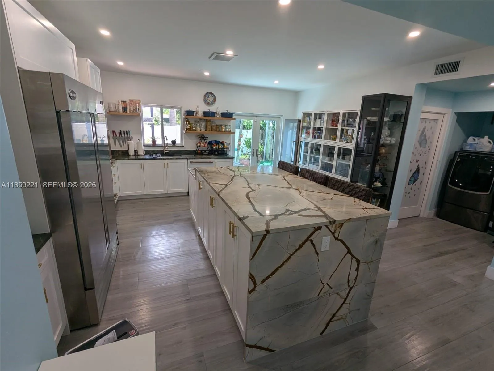 Expansive quartz waterfall island with plenty cabinetry and ample breakfast bar seating for everyday comfort.