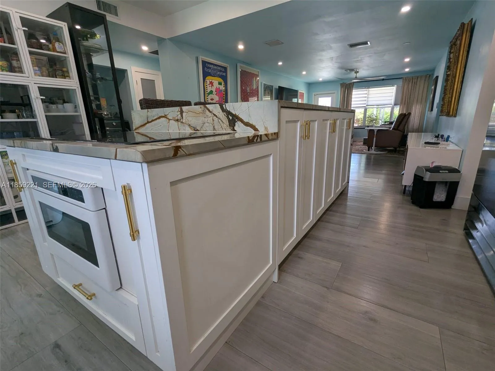 Expansive white cabinets with designer-grade pulls deliver a polished look, blending modern elegance with timeless charm