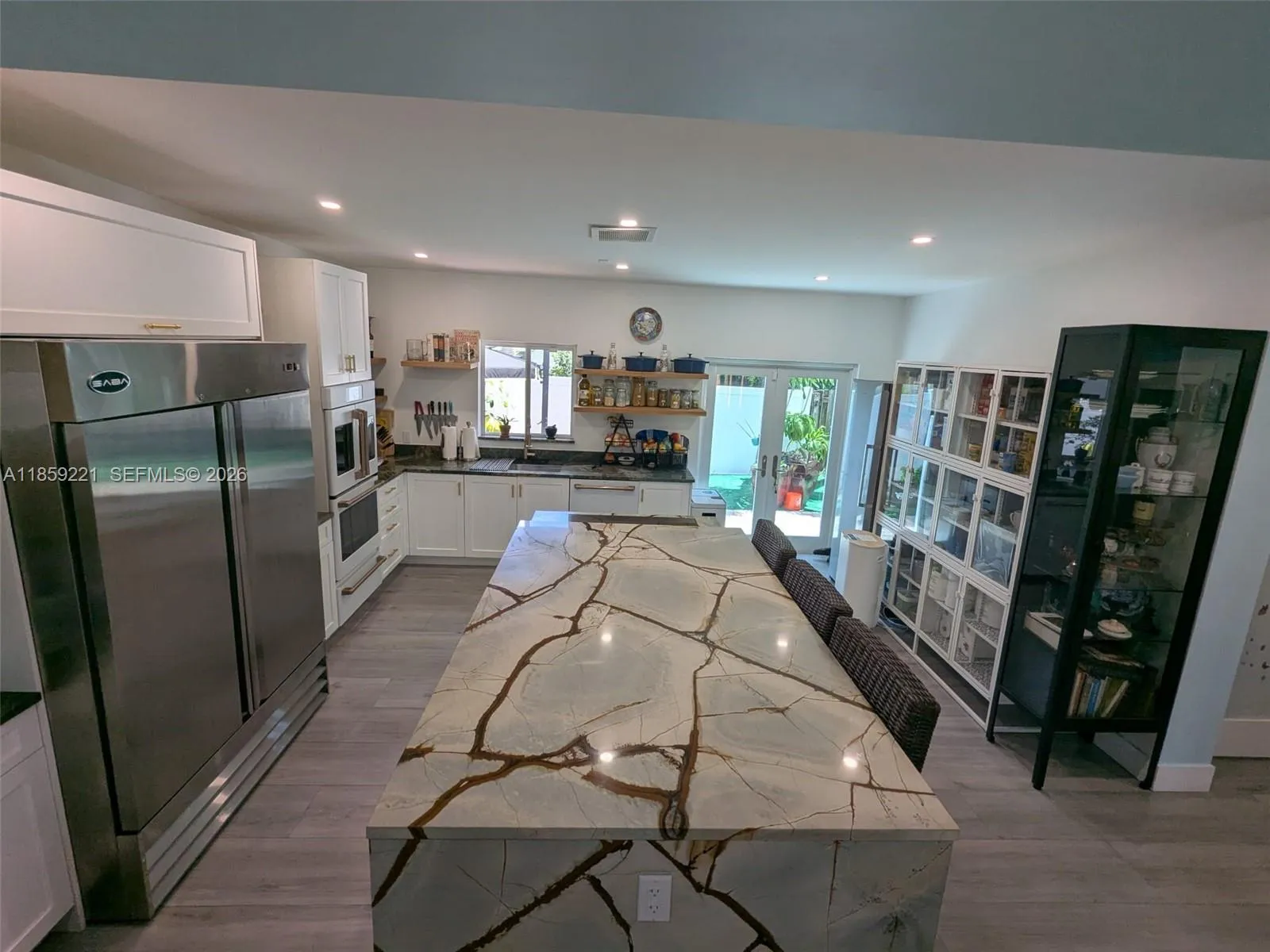Striking quartz waterfall island with generous breakfast seating, perfect for elegant mornings