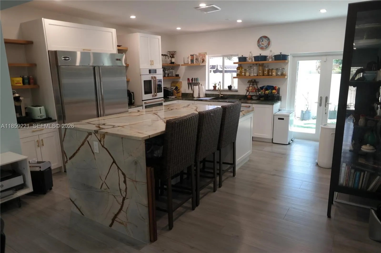 Beautiful quartz island with waterfall edges and plenty of space for family breakfasts. Notice enough room to tuck chairs neatly underneath.