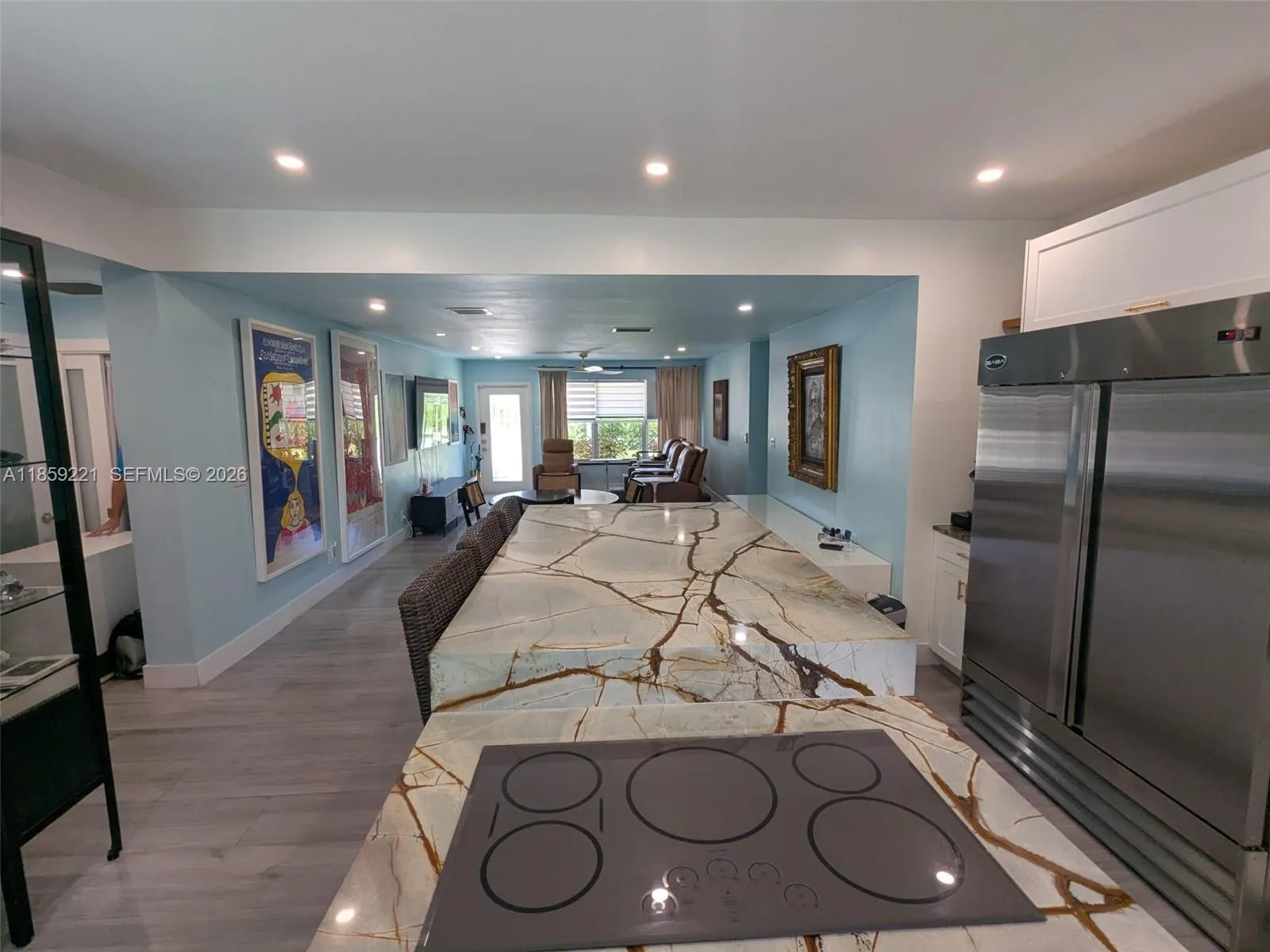 Elegant glass burners pair beautifully with the dual-level quartz waterfall island, blending form and function in a refined kitchen design, perfect for entertaining.