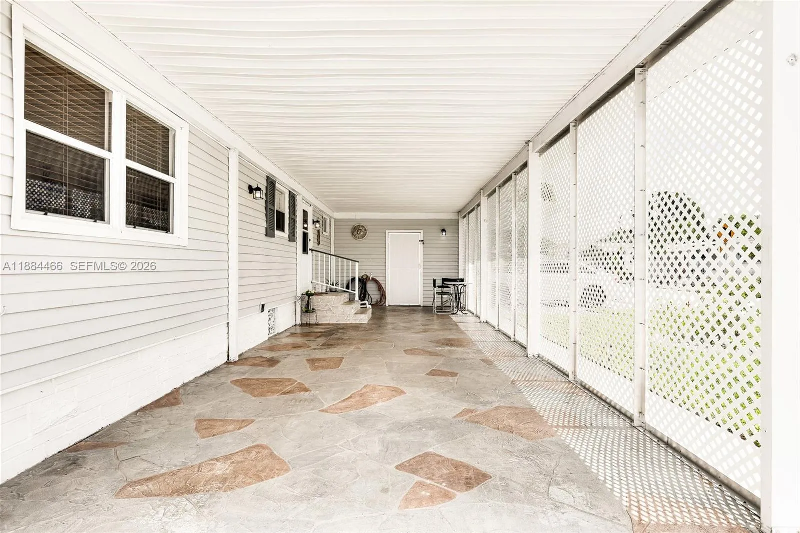 Long carport with stamped concrete driveway. Fits multiple vehicles. New privacy lattice.