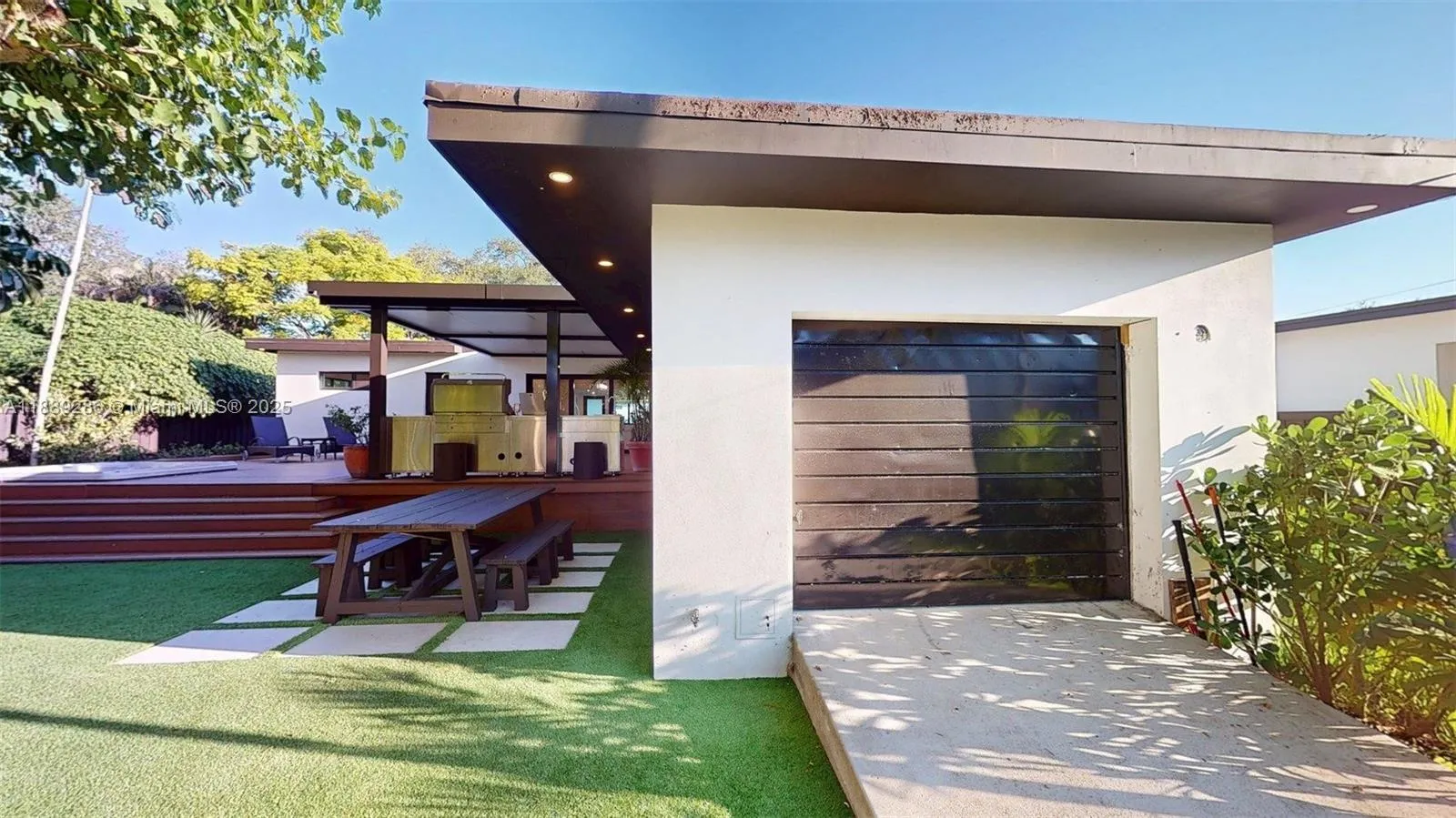 The former garage is now part bedroom and part workshop/storage, accessible, past the sliding gate, from the back alley