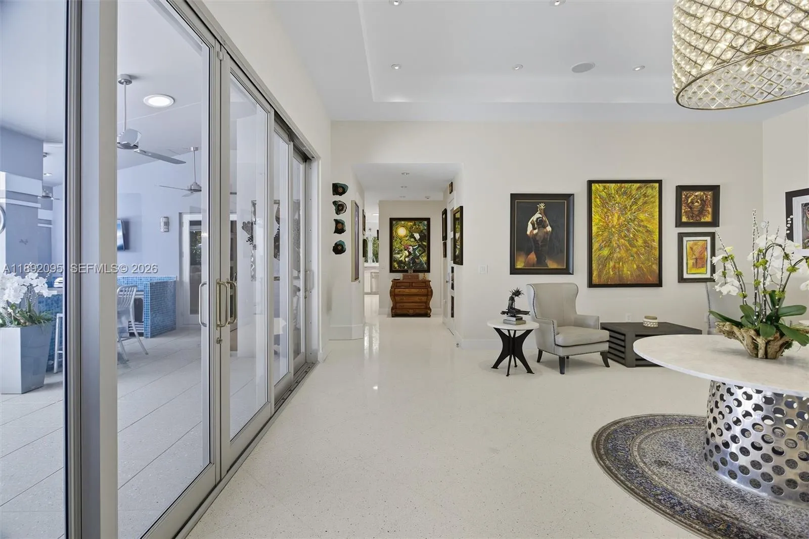 Wall to wall sliding glass doors open to covered terrace