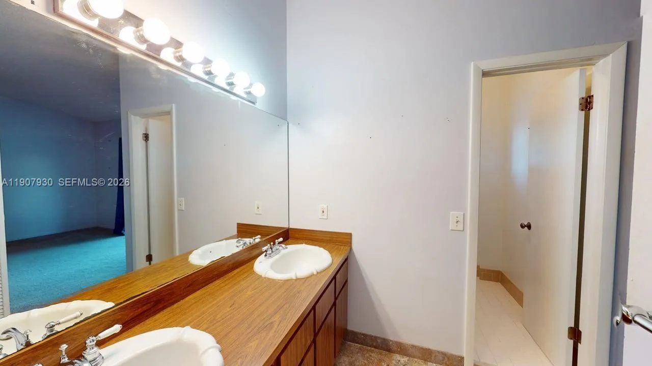 big wide mirror above two unique design sinks and wood cabinets