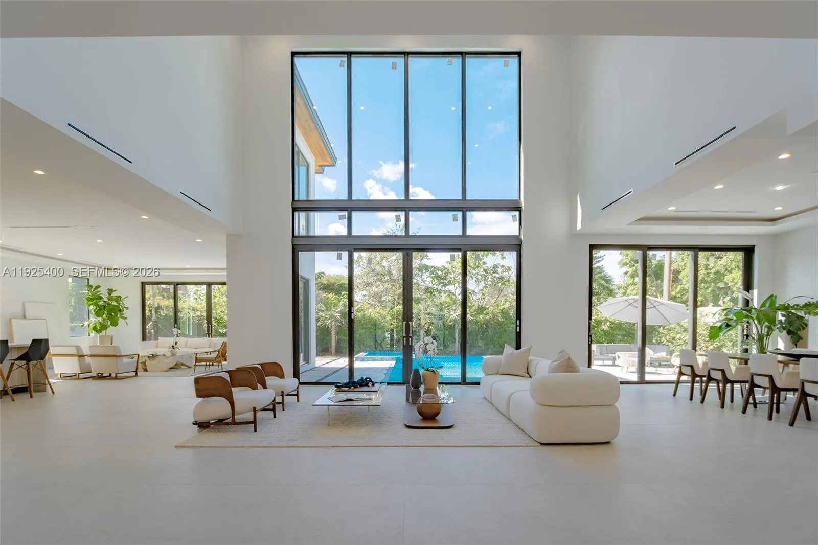 Modern living area with large glass slinding doors that offers a Panoramic view and access to an exterior area.