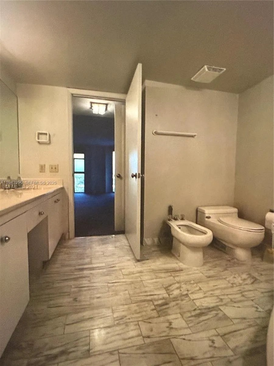 primary bathroom with double sinks, toilet and bidet