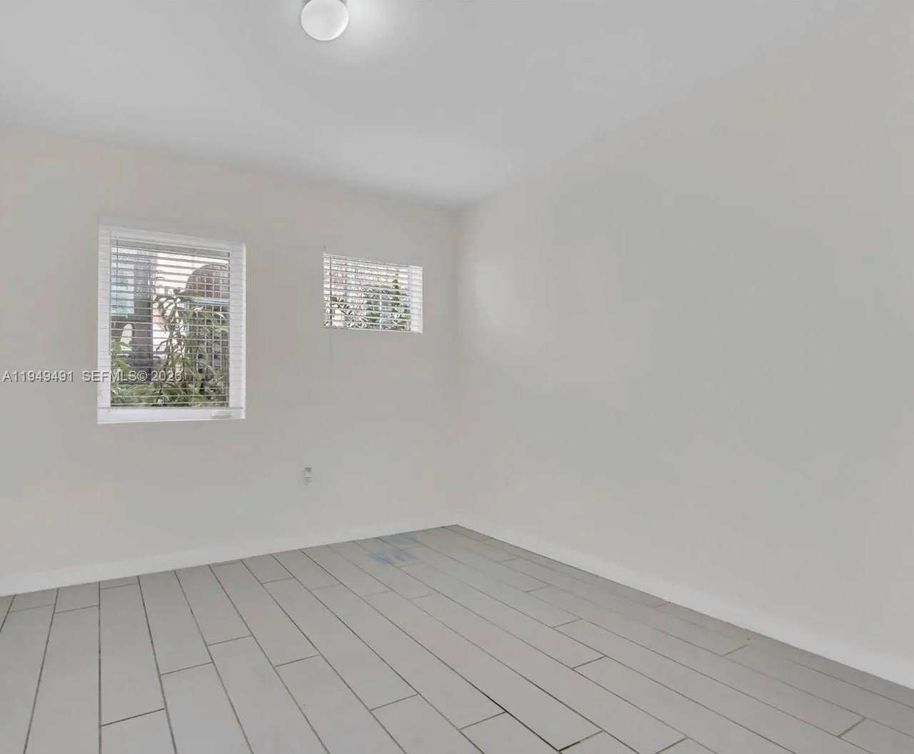 Spacious primary bedroom featuring large closets and modern impact resistant glass.