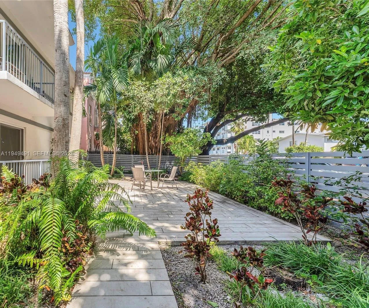 Securely gated boutique building with a tropical courtyard and common BBQ area.