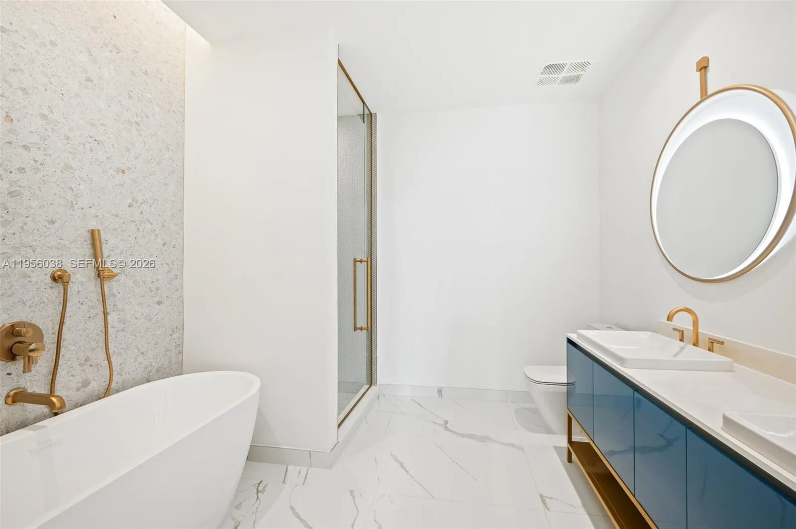 Spa-inspired bathroom featuring sleek modern vanity, quartz countertop, designer fixtures, and glass-enclosed shower with elegant tile finishes at Mr. C Residences Coconut Grove.