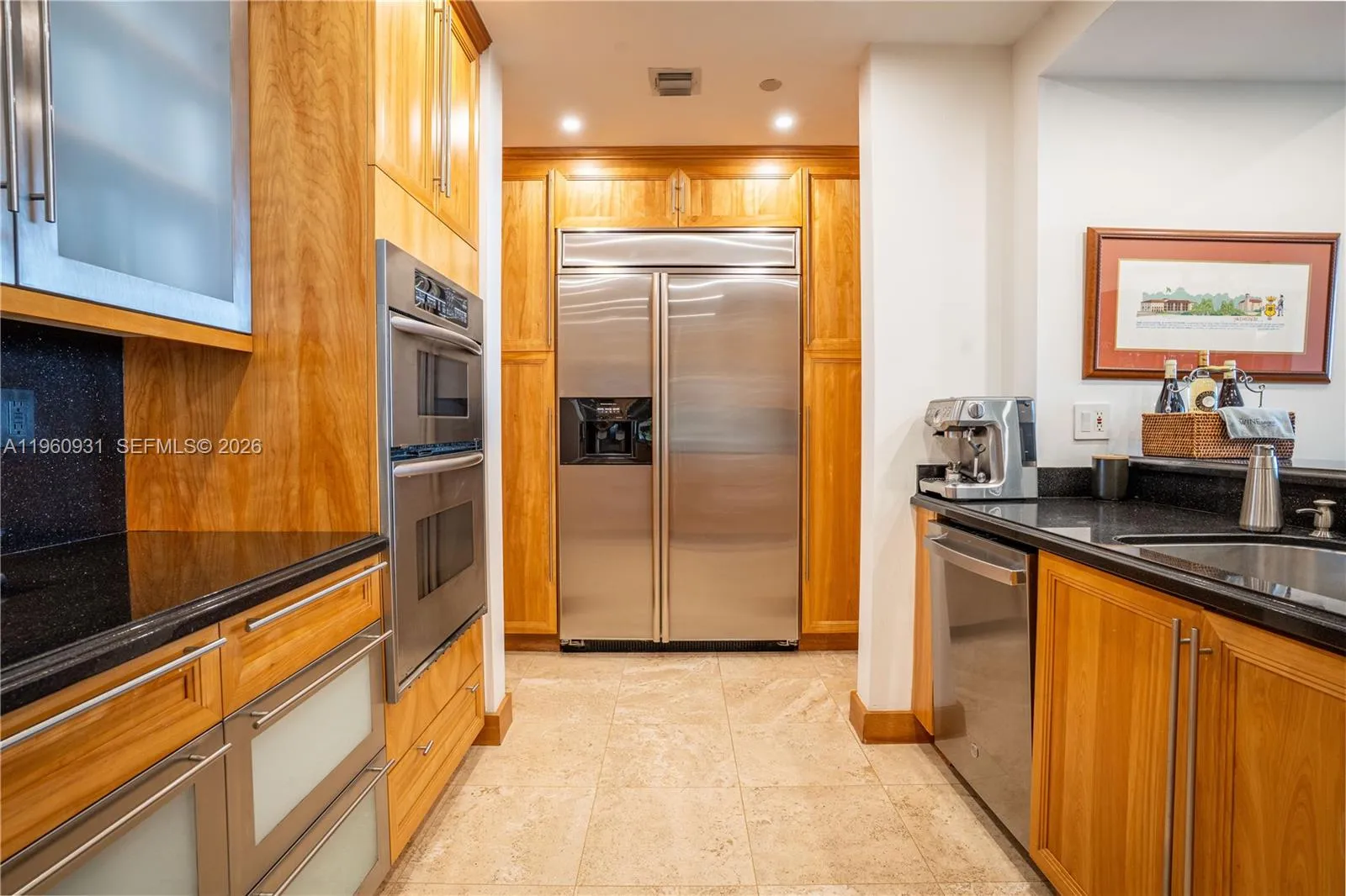 Custom-crafted wood kitchen cabinets and glass cabinets complement the black stone countertop.