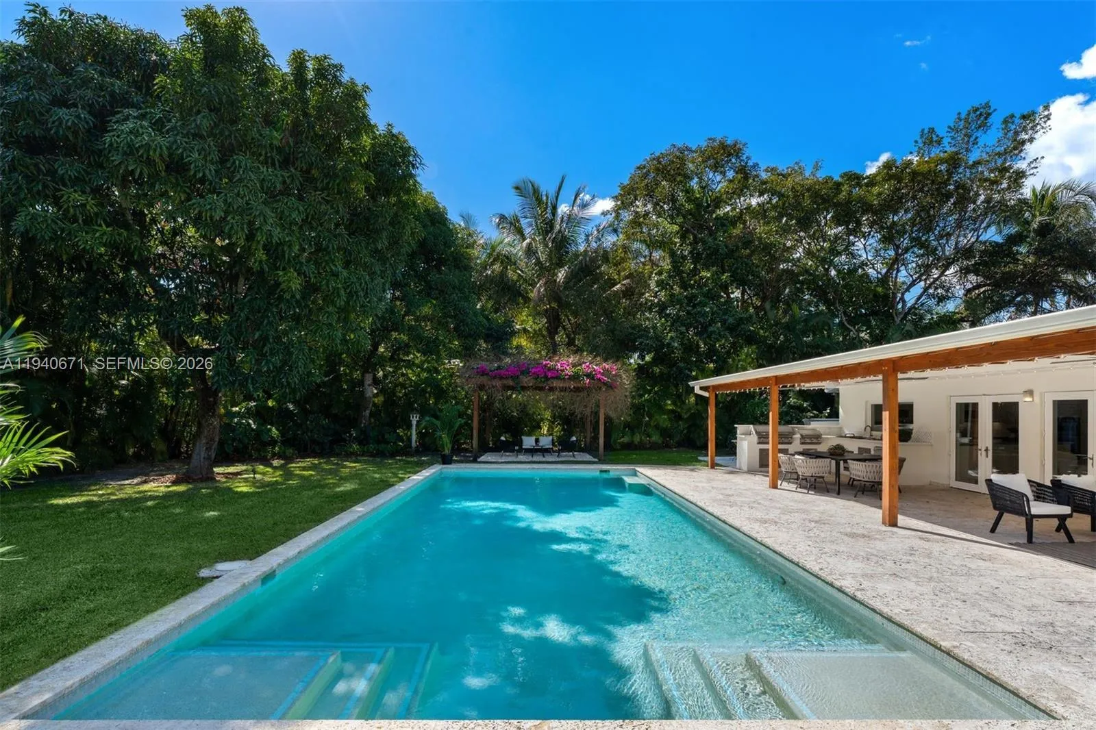 The perfect backyard with sparkling Pool, spacious yard, relaxing pergola, full summer kitchen, expansive veranda