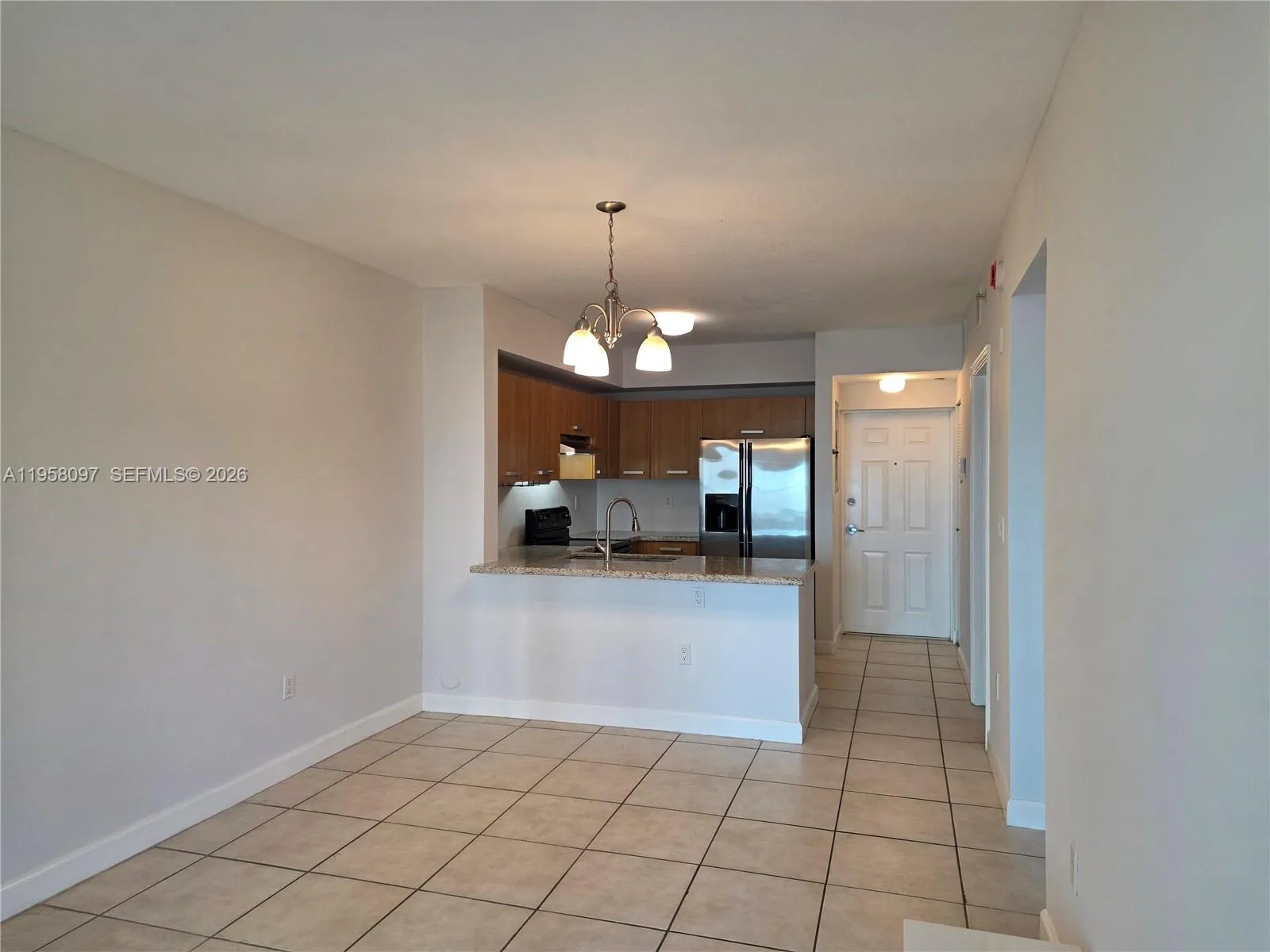 Open kitchen layout with peninsula seating, overlooking the living and dining area for seamless flow and functionality.