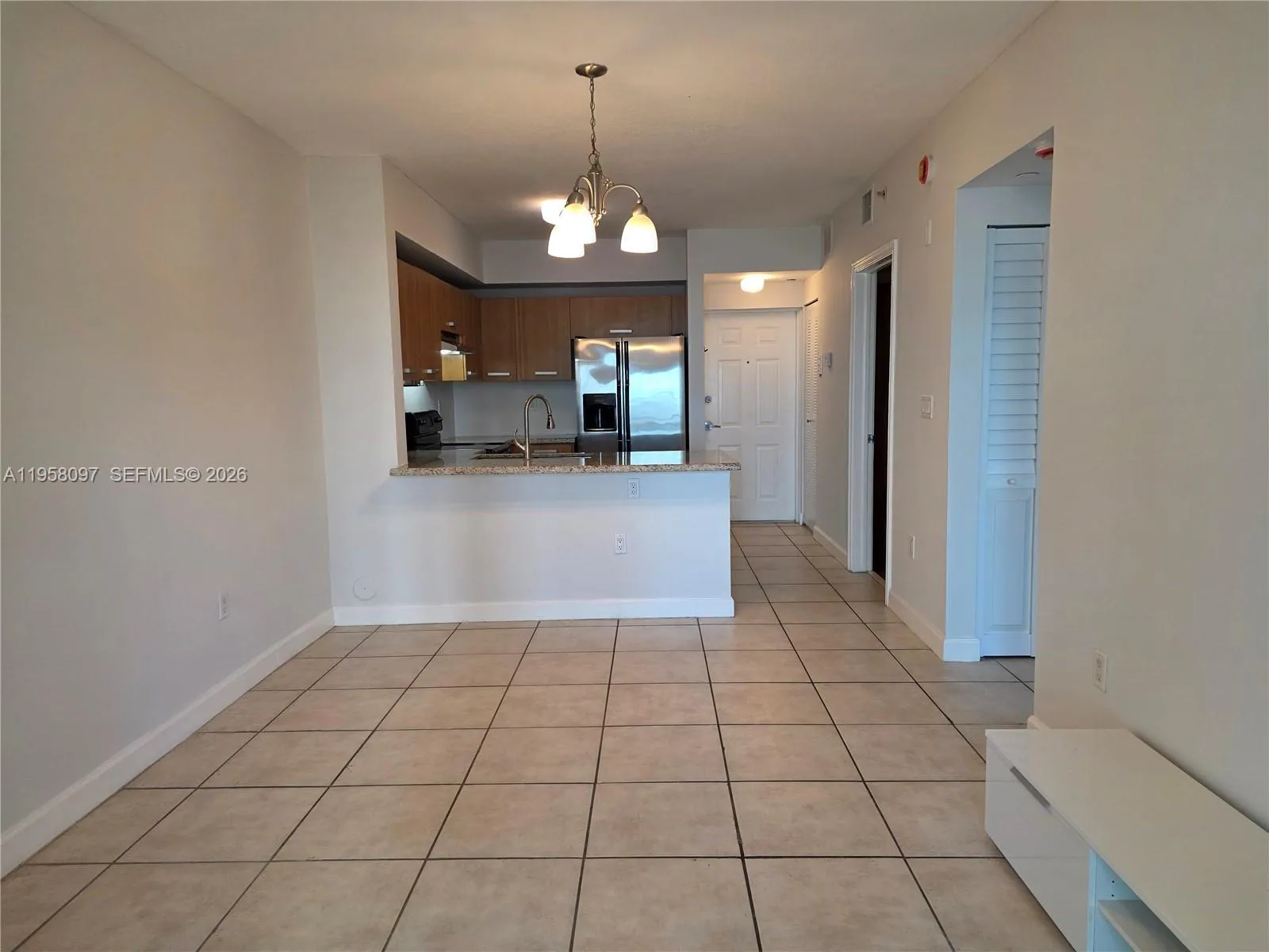 Spacious living and dining space with neutral finishes and tile flooring throughout main areas.