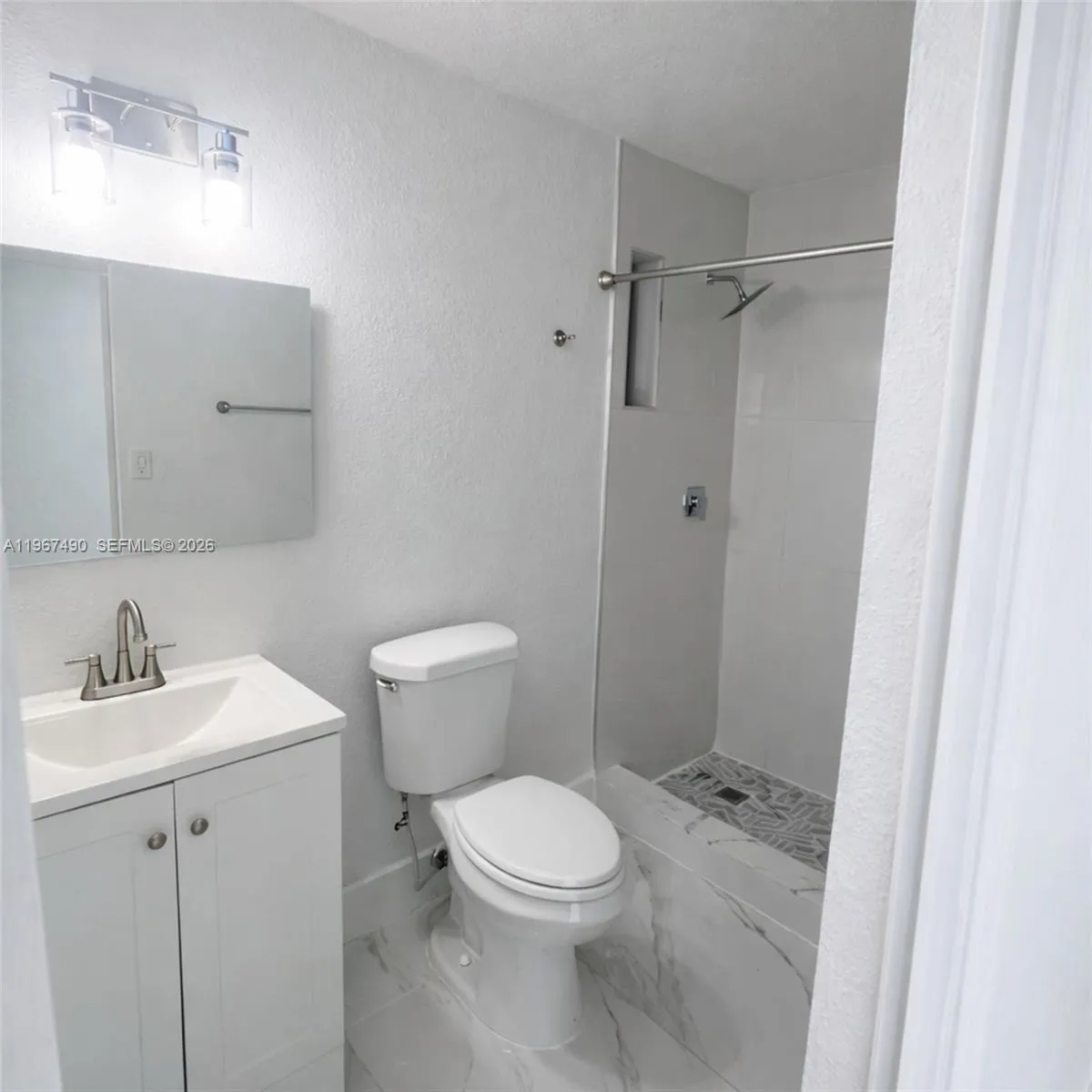 Fully renovated bathroom with modern finishes and walk-in shower.