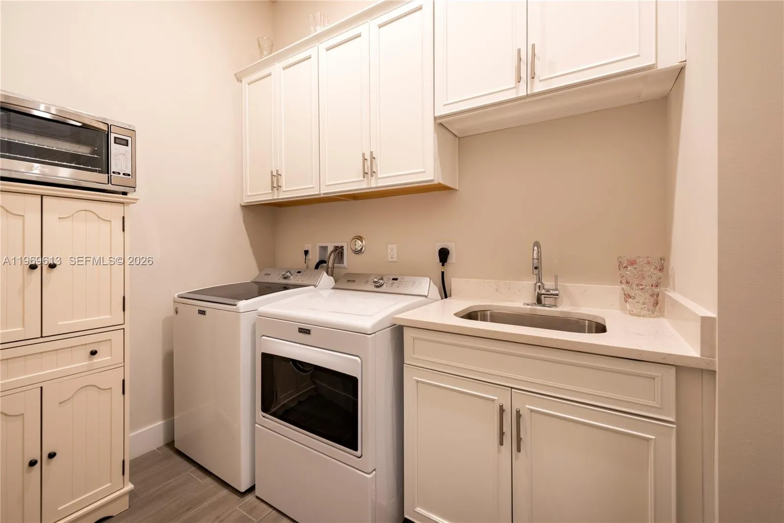 Inside Laundry with Sink and Cabinets