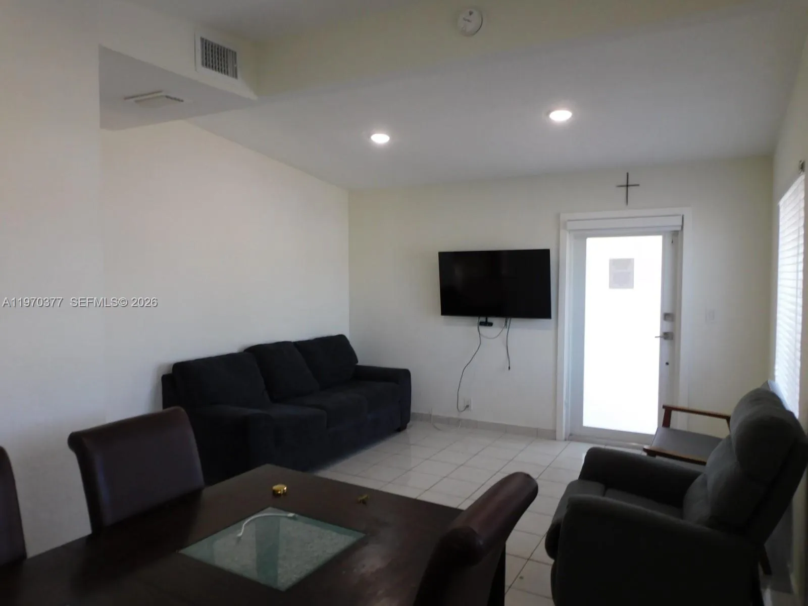 View from dining area to entrance.   High hats, windows bring in lots of natural light.