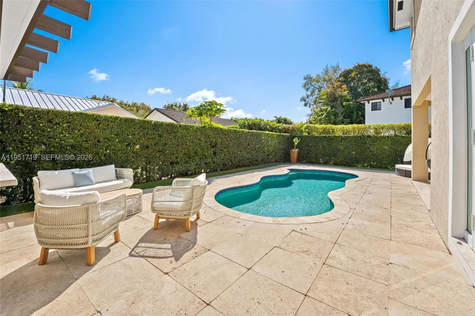 The side yard passage is finished with premium artificial turf and includes a modern stainless steel outdoor shower fixture for poolside convenience.