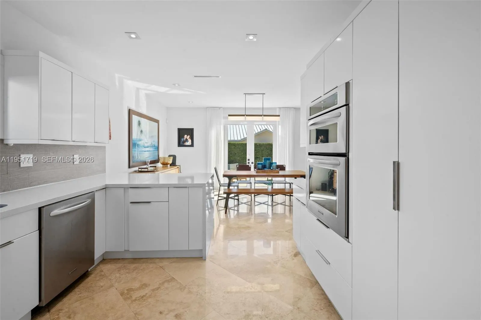 An elegant wooden staircase with a contemporary glass and wood railing leads to the second-level living quarters, maintaining the home\'s open and airy feel.