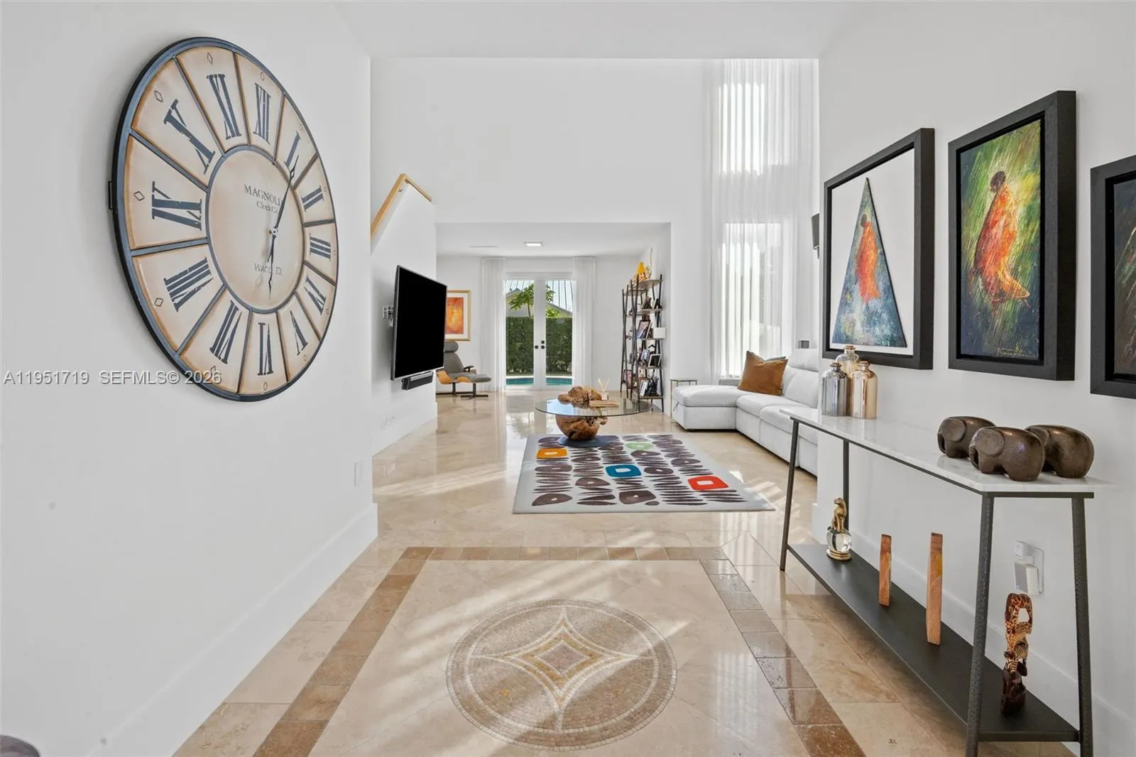 This versatile lounge space offers a perfect retreat with direct access to the backyard and pool through elegant French doors.