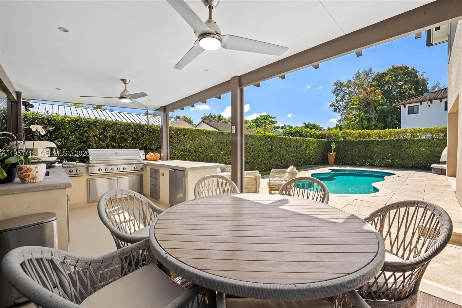 A high-altitude perspective captures the full layout of the private resort-style backyard, including the freeform turquoise pool and the massive covered terrace.