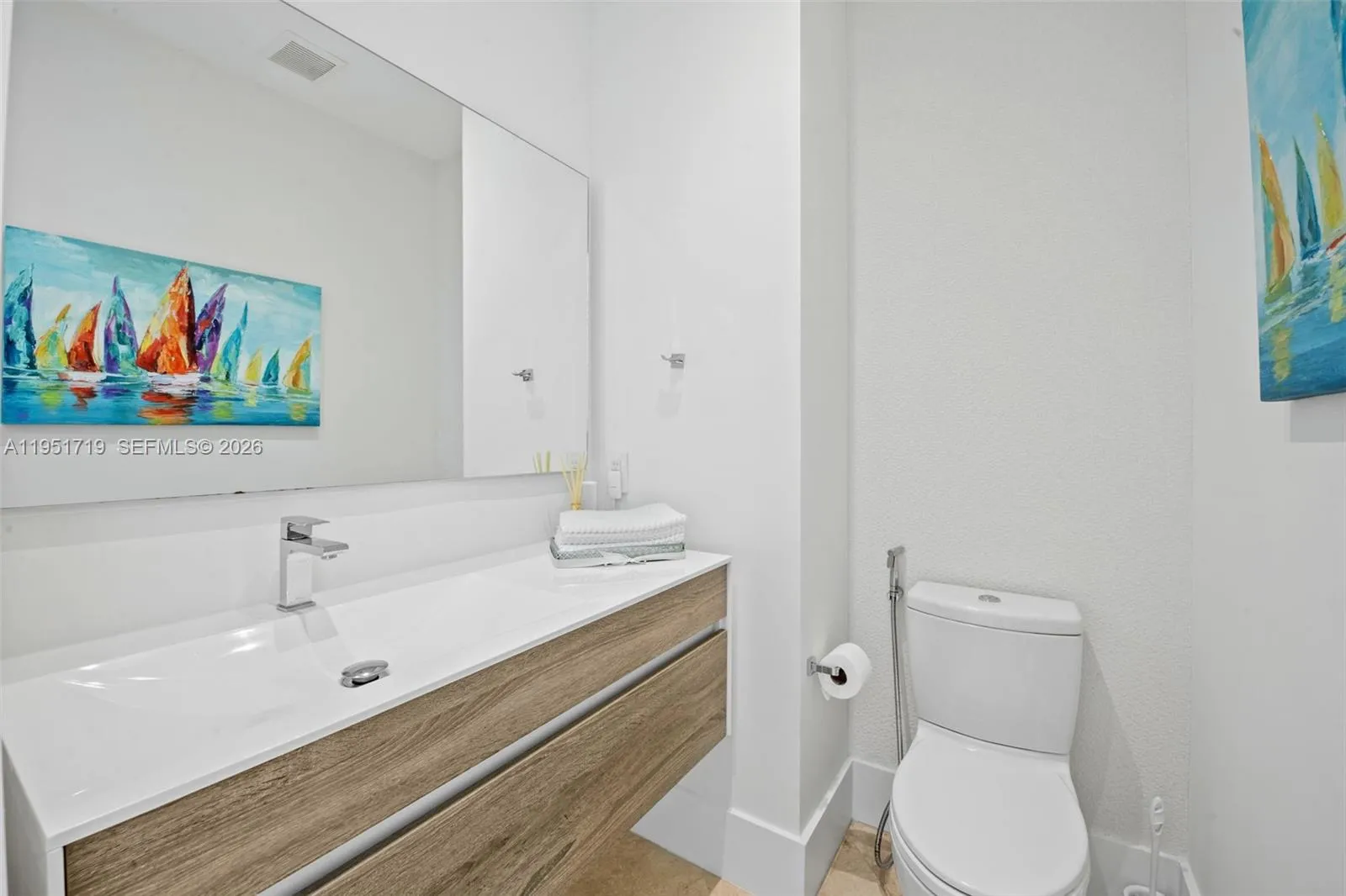 Modern pendant lighting and a neutral color palette enhance the room\'s sophisticated aesthetic, with plenty of space for a king-sized bed and lounge area.